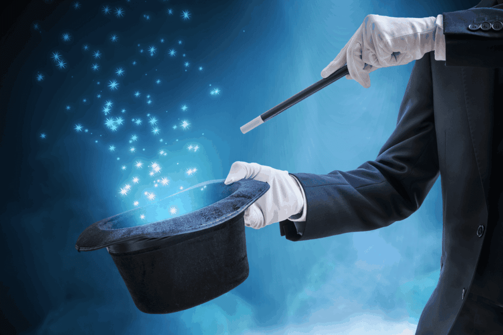 Magicien en costume noir utilisant une baguette pour faire apparaître des étoiles.
