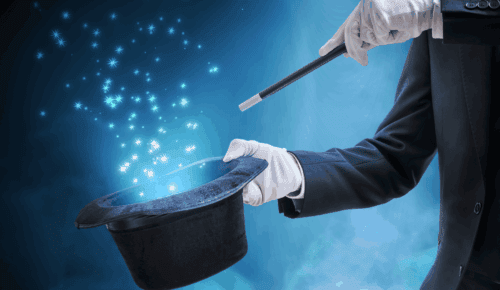 Magicien en costume noir utilisant une baguette pour faire apparaître des étoiles.